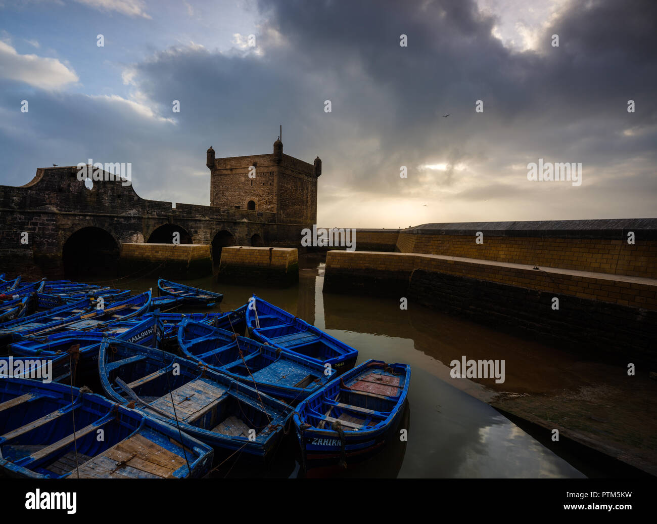 ESSAOUIRA, MAROKKO - ca. Mai 2018: Sonnenuntergang über dem Hafen von Essaouria und die berühmten Castelo Real von Mogador. Stockfoto