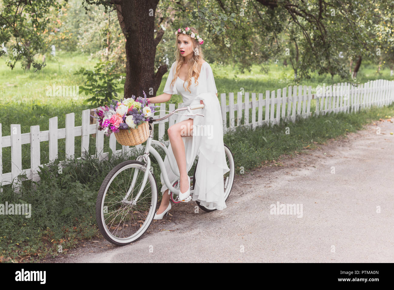 Schöne schockiert Braut im Brautkleid Reiten Fahrrad- und weg schauen Stockfoto