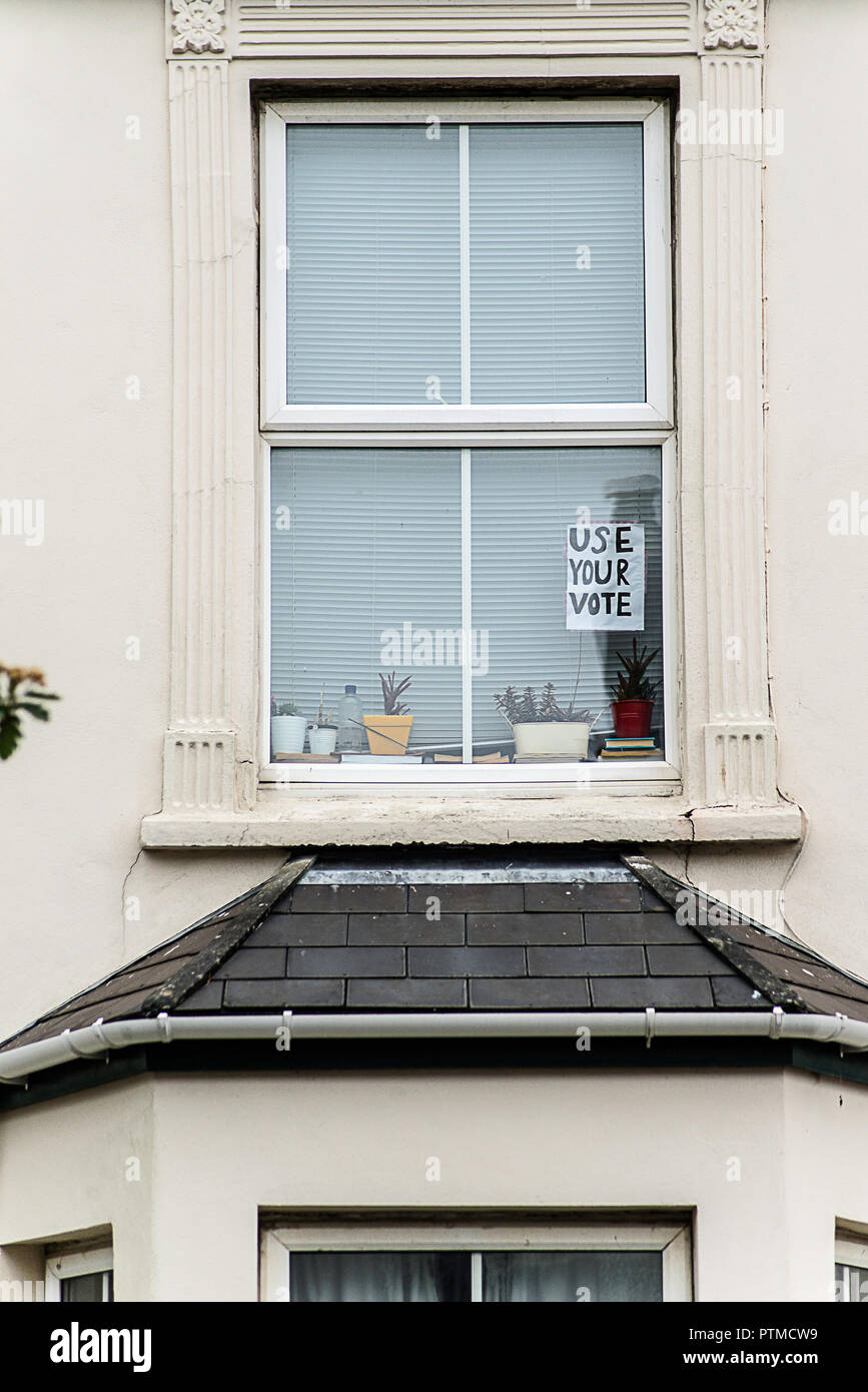 Abstimmung der Arbeit Schilder und Poster an Fenstern und Türen der Häuser in Falmouth, Cornwall. Großbritannien Stockfoto