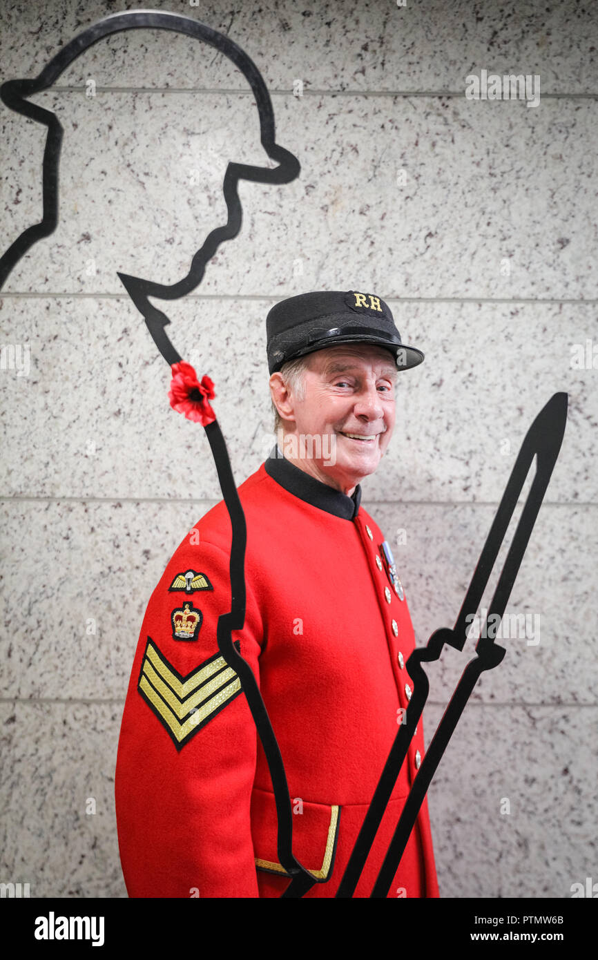 Victoria Station, London, 10. Okt 2018. Chelsea Rentner Tony, der gerade 80 geworden ist, wirft mit der Tommy Abbildung, eine Übersicht Skulptur eines WW1 Soldaten, in der Victoria Station. Die Veteranen sammeln Spenden in zwölf Londoner U-Bahn-Stationen, heute im Namen der Nächstenliebe "erinnert". Eröffnungs-Projekt der Nächstenliebe", es aber nicht Es' hat das Ziel, zum Gedenken an jene, die in der WK 1 starb, die Jungen zu erziehen und die heutigen Veteranen leiden von der mentalen und körperlichen Wunden der Service während der Hundertjahrfeier 2018 heilen. Credit: Imageplotter Nachrichten und Sport/Alamy leben Nachrichten Stockfoto