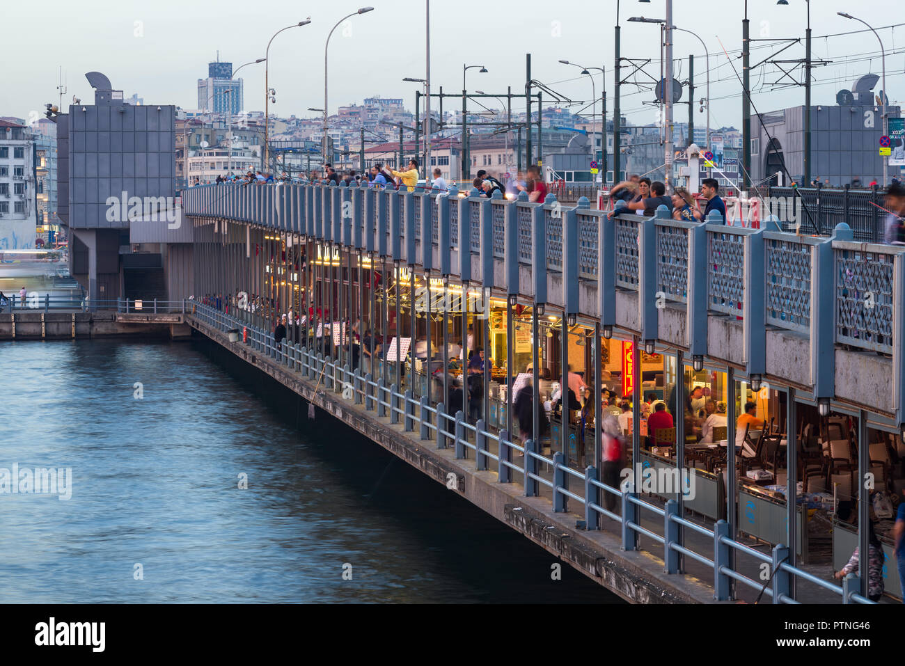 Galata Brücke mit Fischern Fischen bei Sonnenuntergang mit Menschen vorbei gehen, Istanbul, Türkei Stockfoto