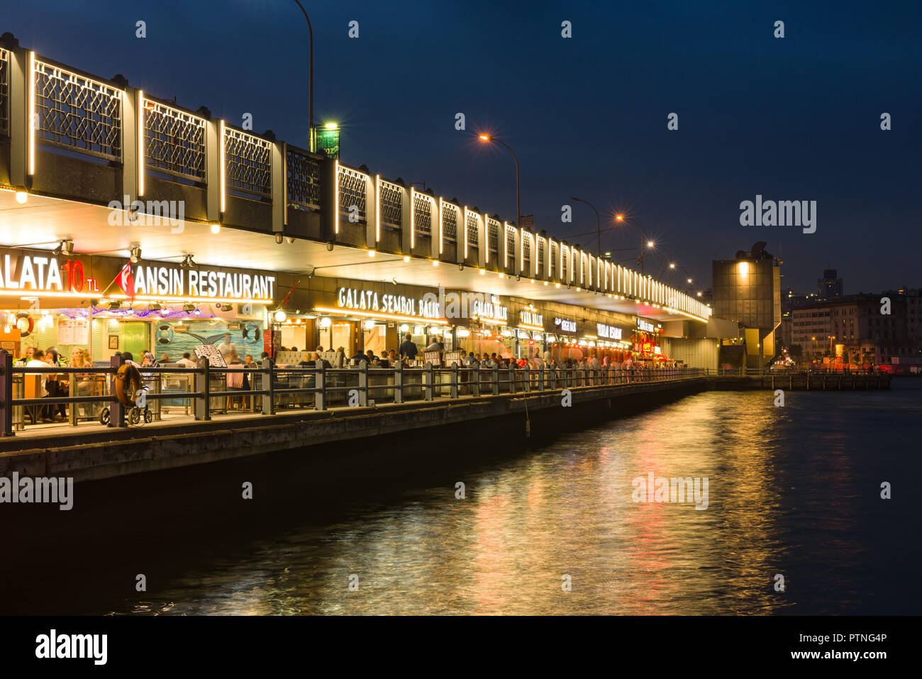 Galata Brücke bei Dämmerung mit Restaurants leuchtet, können die Gäste in den Restaurants, Istanbul, Türkei gesehen werden. Stockfoto