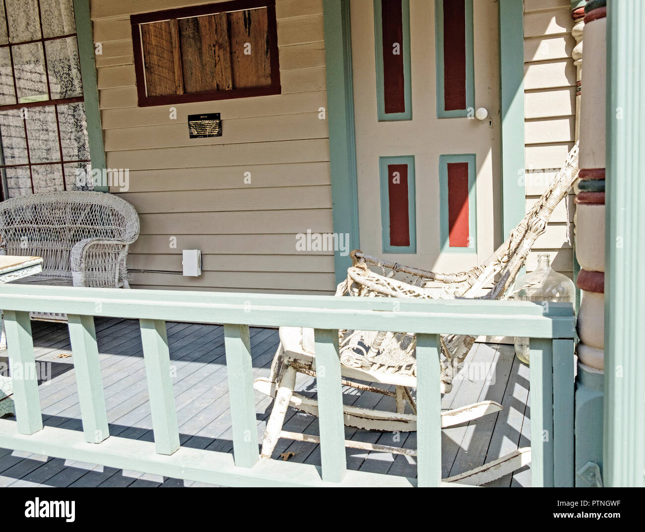 Rattan Schaukelstuhl und Zweisitzersofa auf der Veranda des alten geschuppt Haus. Dulaney Cottage, Kastanie Square Historic Village, McKinney, Texas. Stockfoto