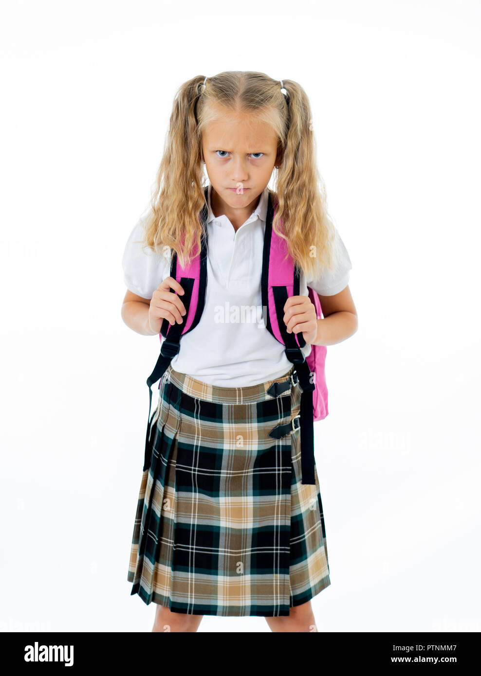 Süße kleine schöne Mädchen in Schuluniform wütend und frustriert auf die Kamera auf weißem Hintergrund in Hausaufgaben lernen dif isoliert Stockfoto