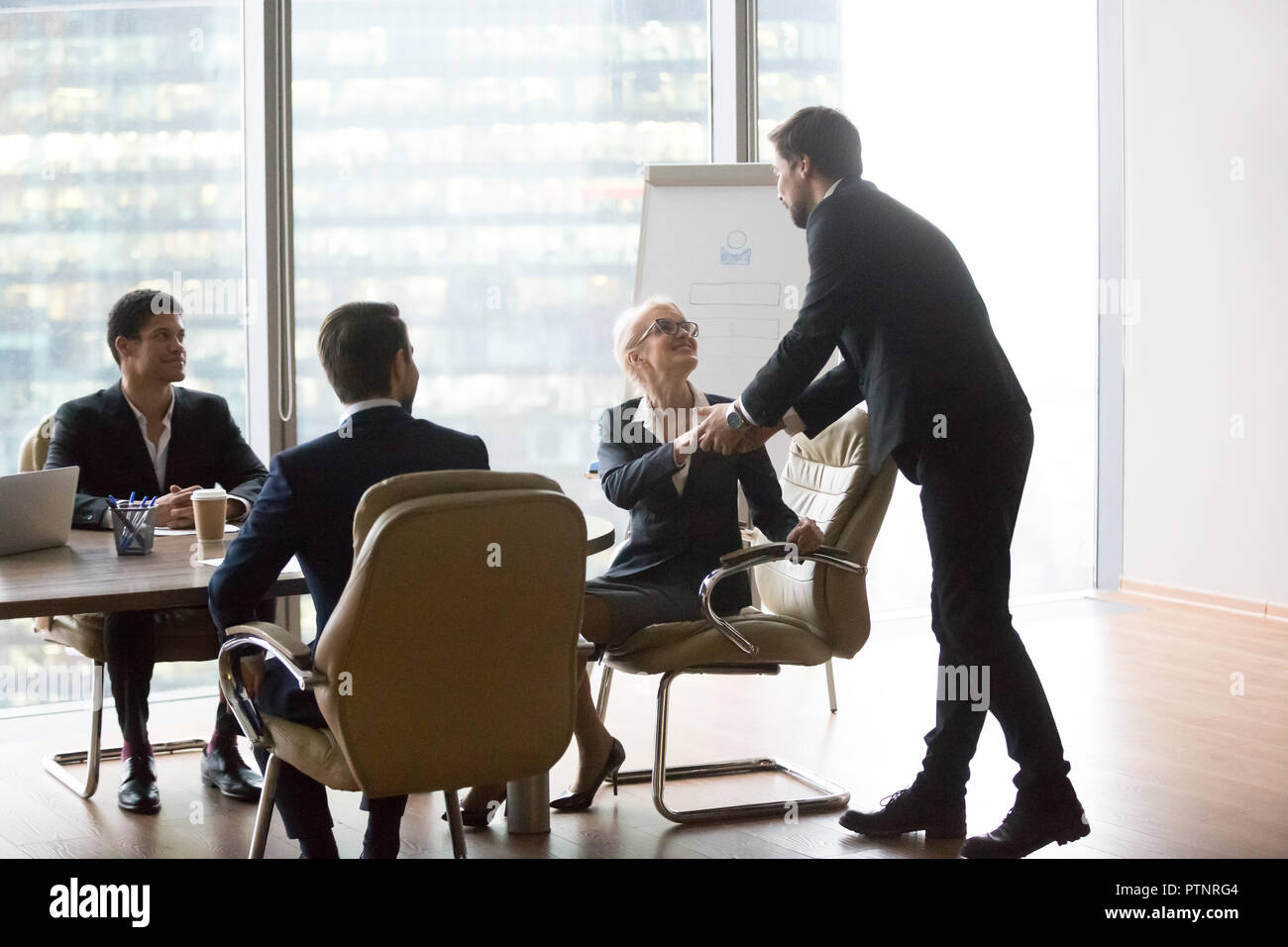Männliche Moderator handshaking Geschäftsfrau vor Präsentation Giv Stockfoto