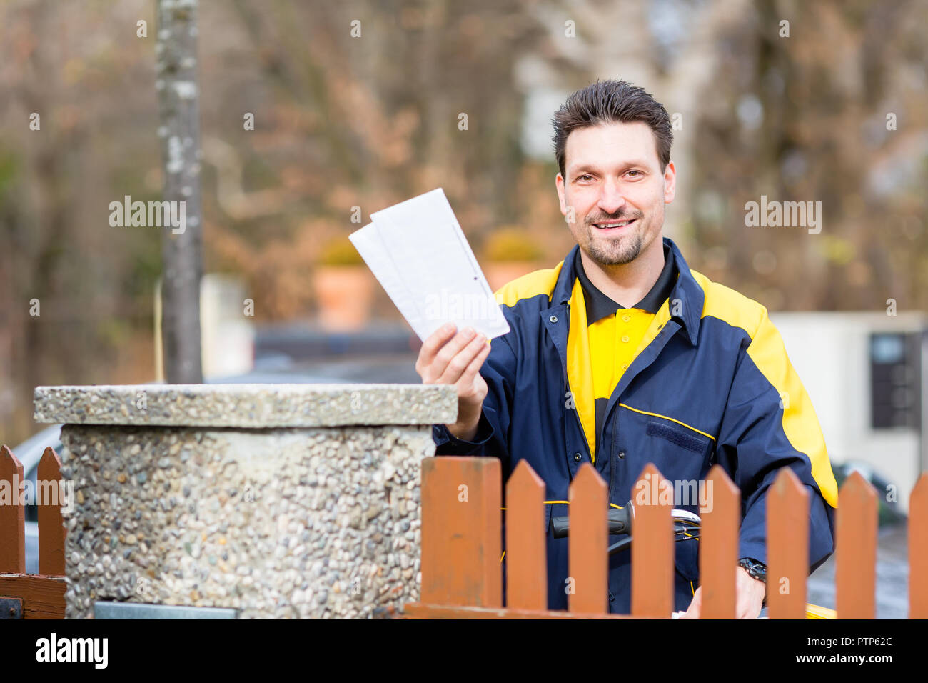 Der Postbote die Briefe an die Mailbox des Empfängers Stockfoto