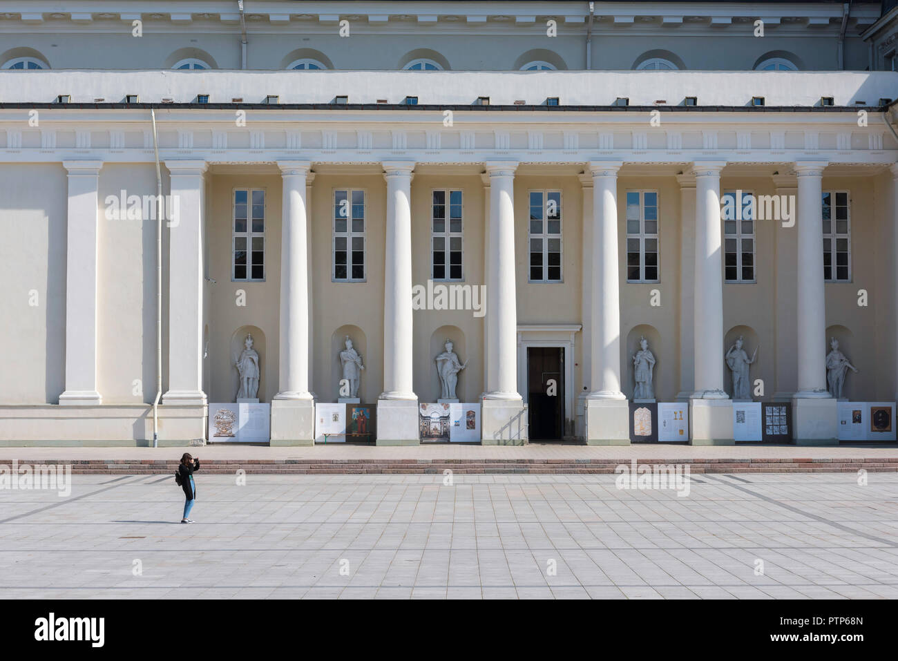 Frau allein reisen, eine junge Frau mit einem Rucksack nimmt ein Foto, während allein in einer europäischen Stadt Platz. Stockfoto