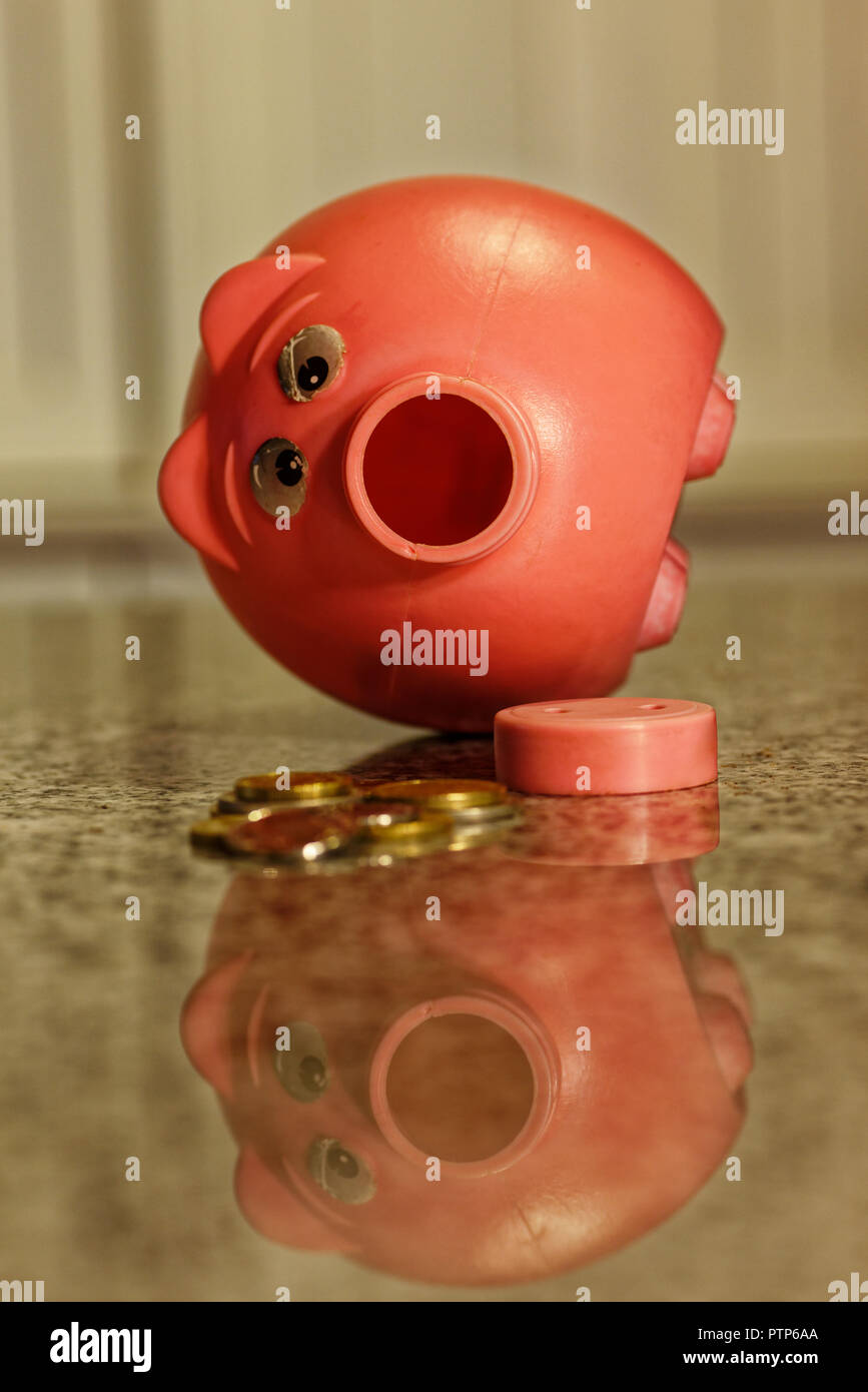 Rosa Sparschwein mit Nase aus und Geld herausgenommen und auf Zähler Stockfoto