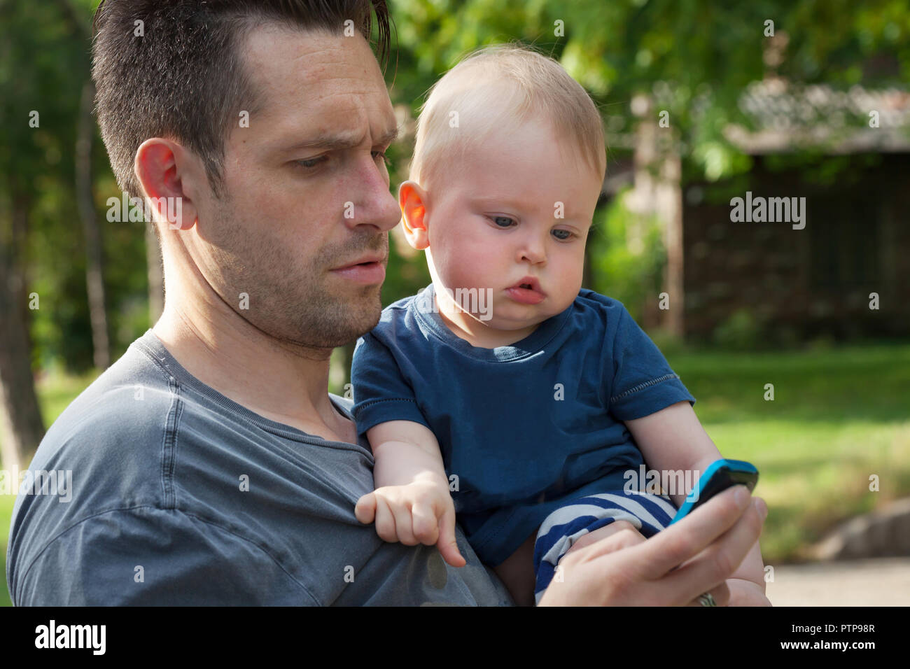 Vater und Sohn in einem Handy Spaß - Alleinerziehende und 13 Monate alten Babys genießen im Freien suchen Stockfoto
