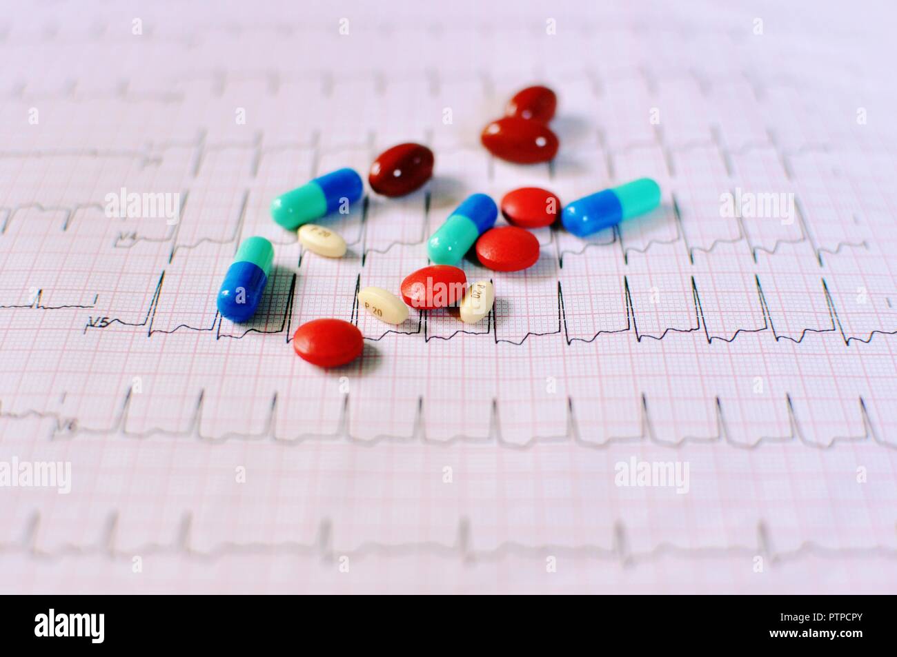 Nahaufnahme von verschiedenen Arten von Pillen, Tabletten und Drogen auf Elektrokardiogramm (EKG oder EKG-Papier) Hintergrund für Gesundheitswesen und medizinische Konzept. Stockfoto