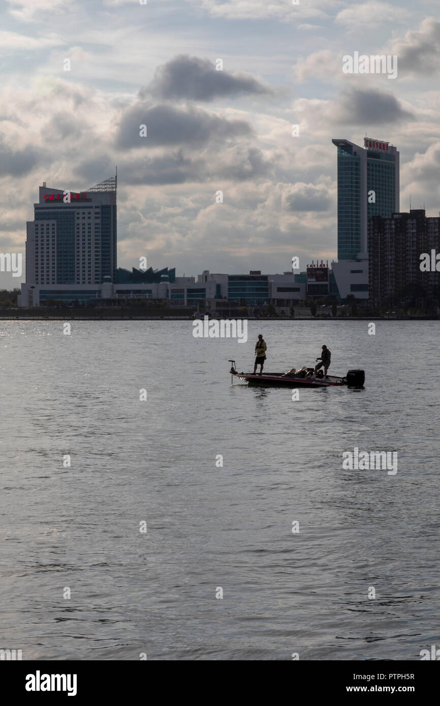 Detroit, Michigan - zwei Männer aus einem kleinen Boot auf dem Detroit River. Windsor, Ontario, Kanada ist auf der anderen Seite. Stockfoto