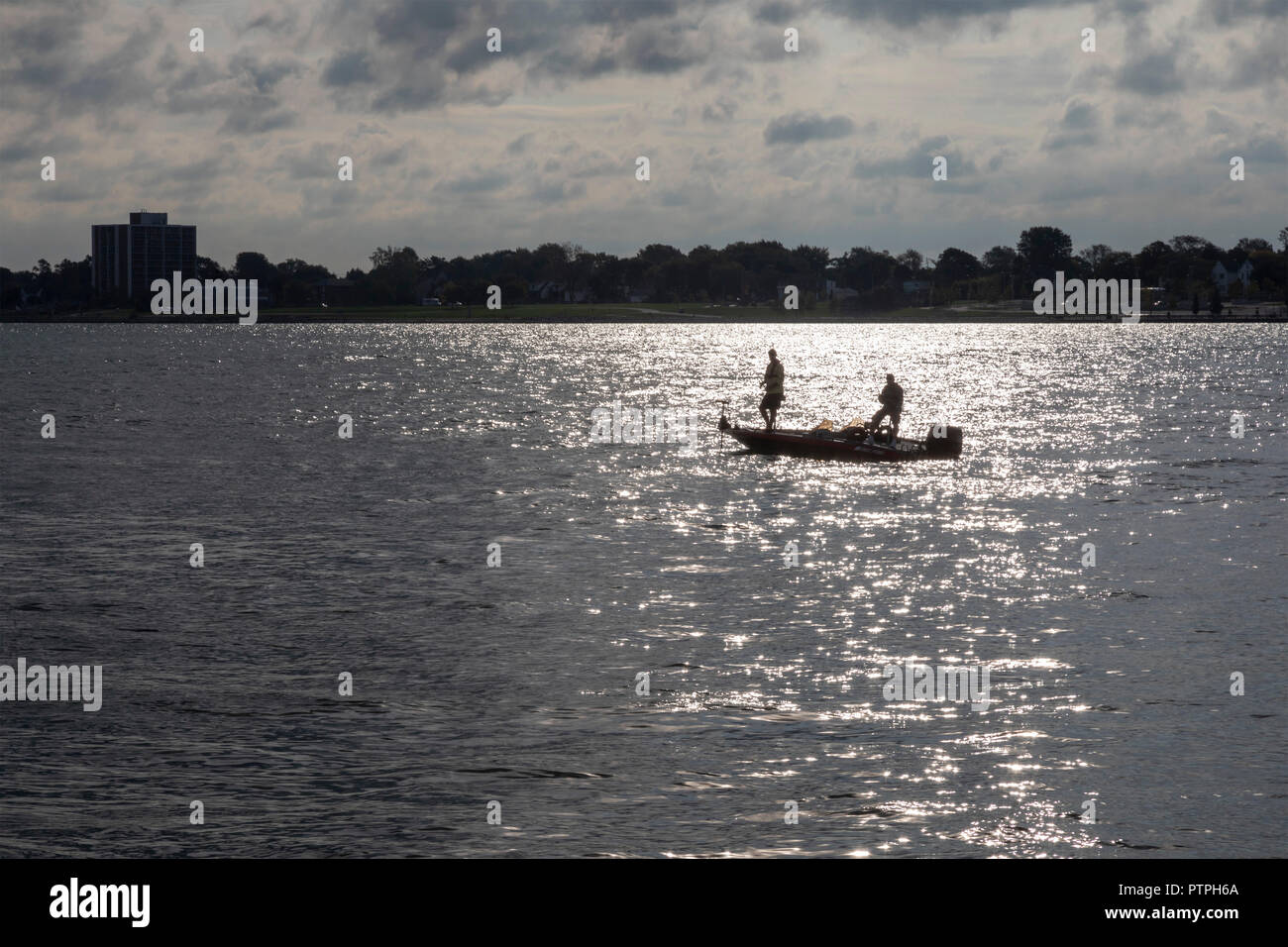Detroit, Michigan - zwei Männer aus einem kleinen Boot auf dem Detroit River. Windsor, Ontario, Kanada ist auf der anderen Seite. Stockfoto