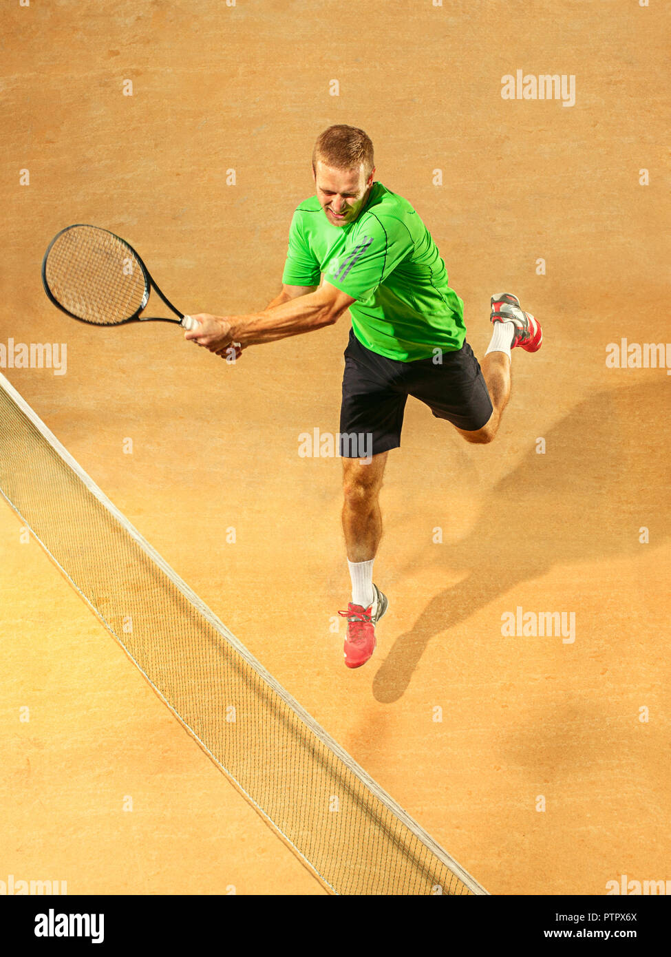 Ich bin mit dem Speichern dieser Ball jetzt. Spieler Ausfallschritt, Spiel der Verteidigung. Die kaukasischen passen Mann spielt Tennis an der irdenen Gericht. Player jumping in voller Länge mit Schläger und Ball. Emotionen im Gesicht. Obere Ansicht von oben Stockfoto