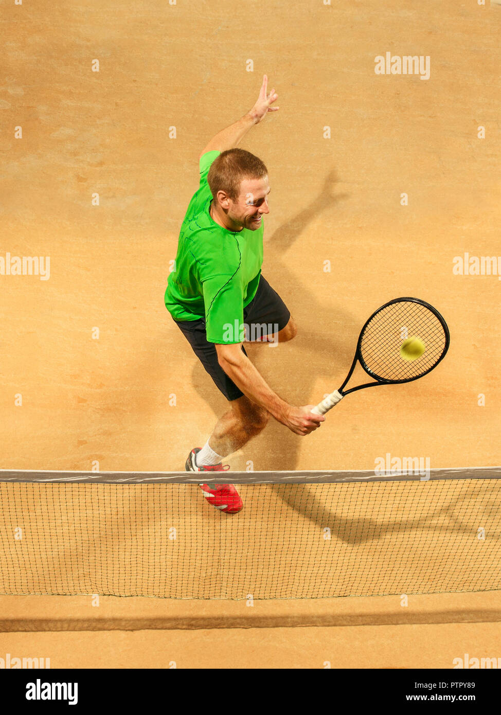 Ich bin mit dem Speichern dieser Ball jetzt. Spieler Ausfallschritt, Spiel der Verteidigung. Die kaukasischen passen Mann spielt Tennis an der irdenen Gericht. Player jumping in voller Länge mit Schläger und Ball. Emotionen im Gesicht. Obere Ansicht von oben Stockfoto