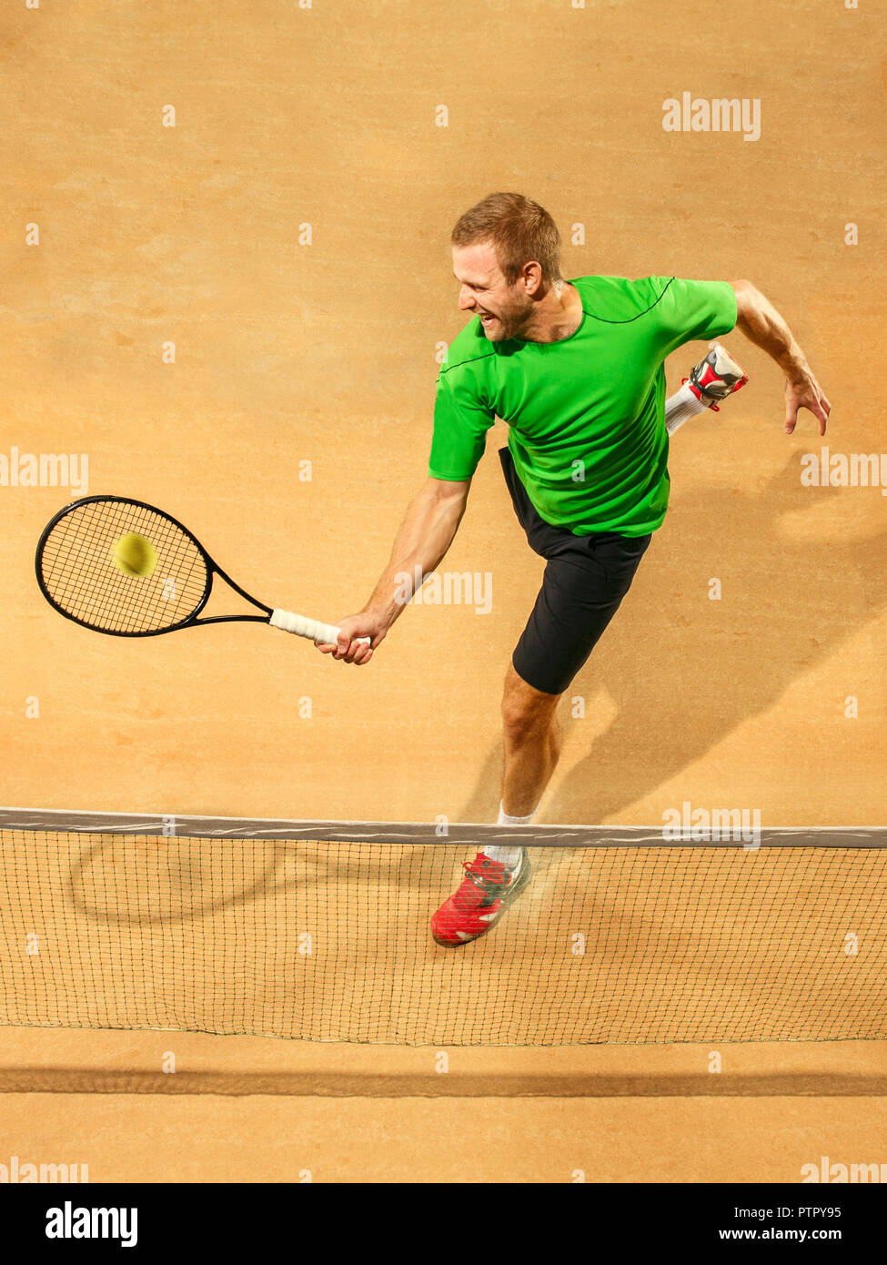 Ich bin mit dem Speichern dieser Ball jetzt. Spieler Ausfallschritt, Spiel der Verteidigung. Die kaukasischen passen Mann spielt Tennis an der irdenen Gericht. Player jumping in voller Länge mit Schläger und Ball. Emotionen im Gesicht. Obere Ansicht von oben Stockfoto