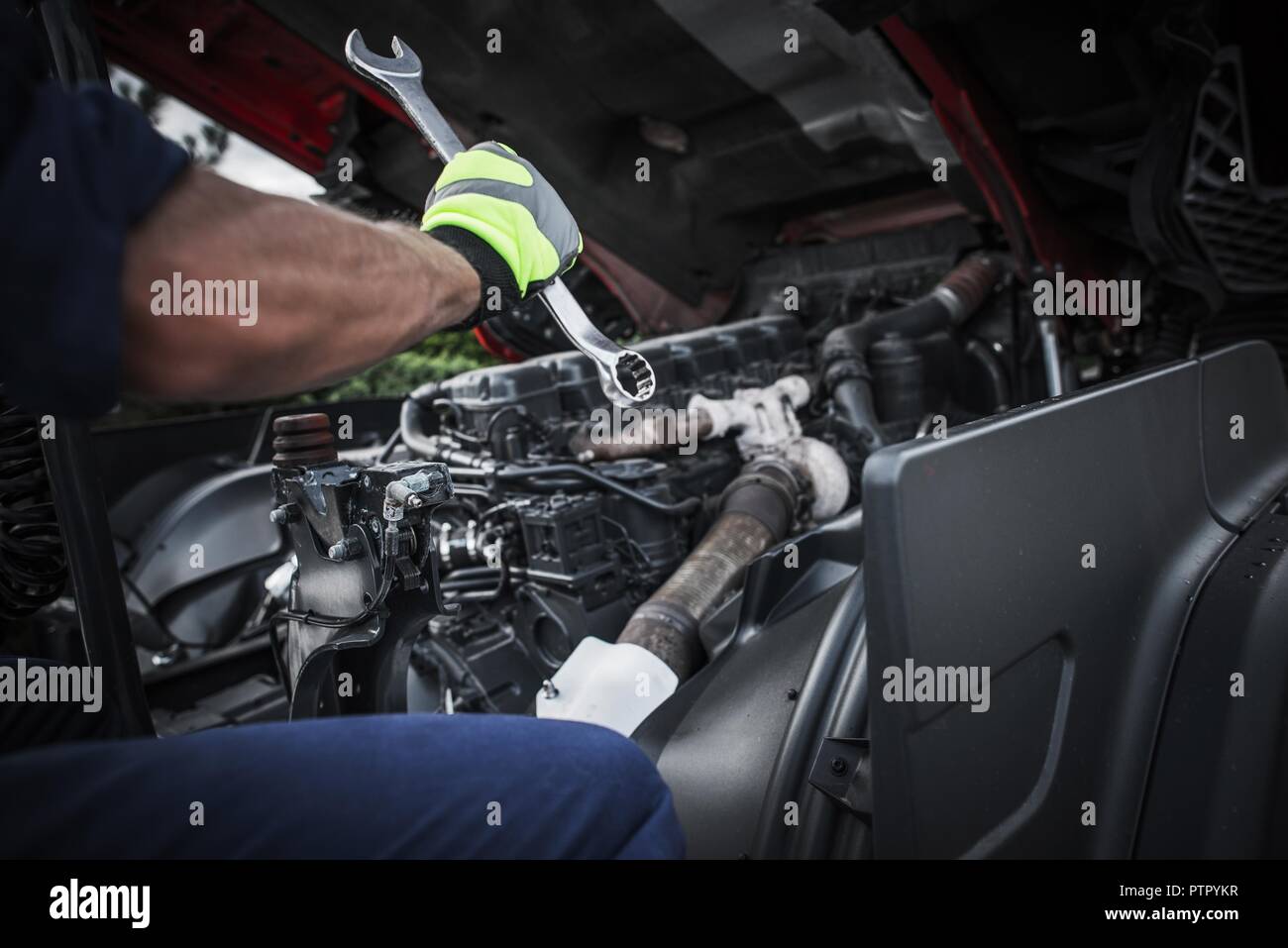Kaukasische Lkw Mechaniker reparieren Semi Truck Motor. Stockfoto