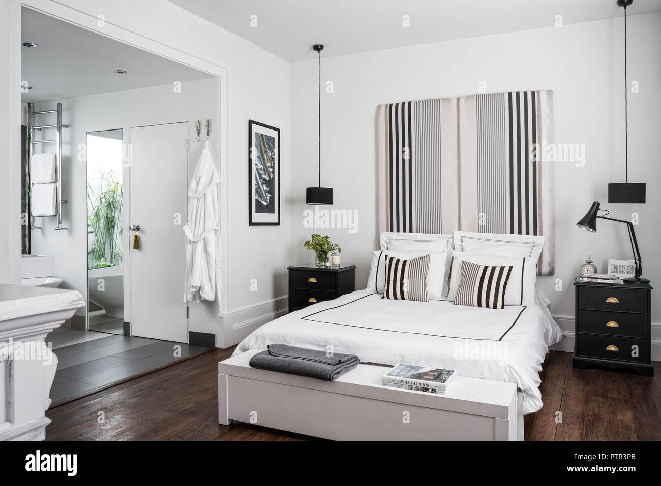 Doppelbett mit Kopfteil in Ariana Parini Stoff aus dem Designers Guild bedeckt mit Bettwäsche von White Company Stockfoto