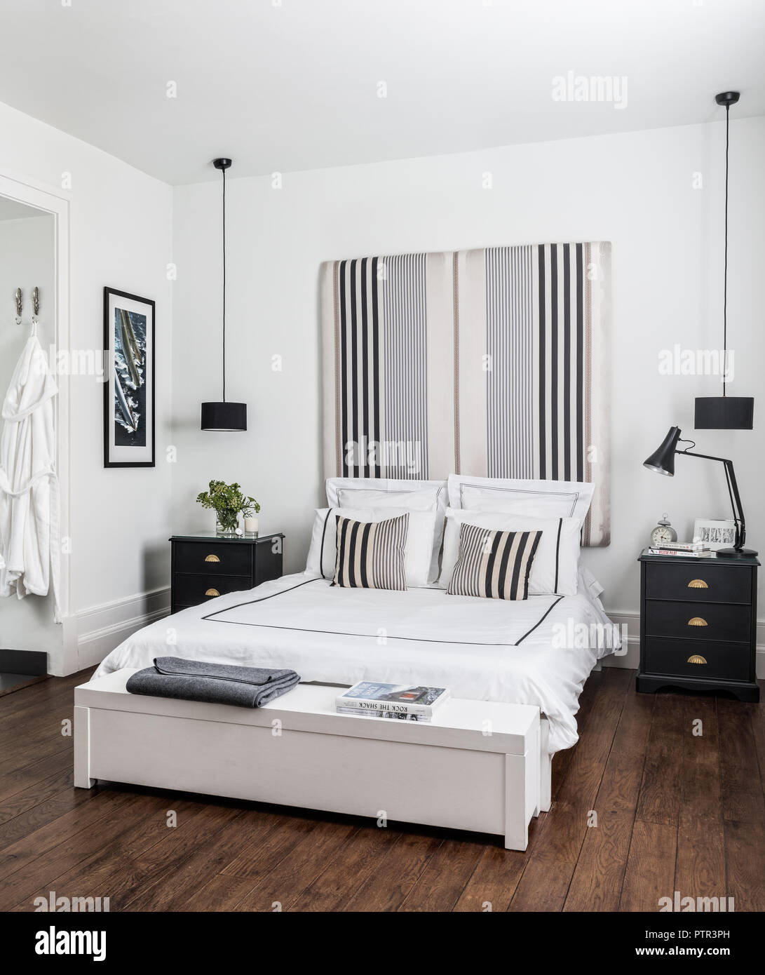 Doppelbett mit Kopfteil in Ariana Parini Stoff aus dem Designers Guild bedeckt mit Bettwäsche von White Company Stockfoto