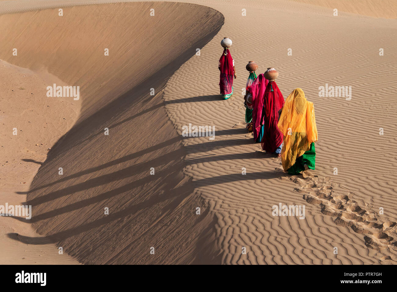Das Bild der Rajasthani aus massivem Messing Damen mit Töpfe in den Sanddünen von Jaisalmer, Rajasthan, Indien Stockfoto