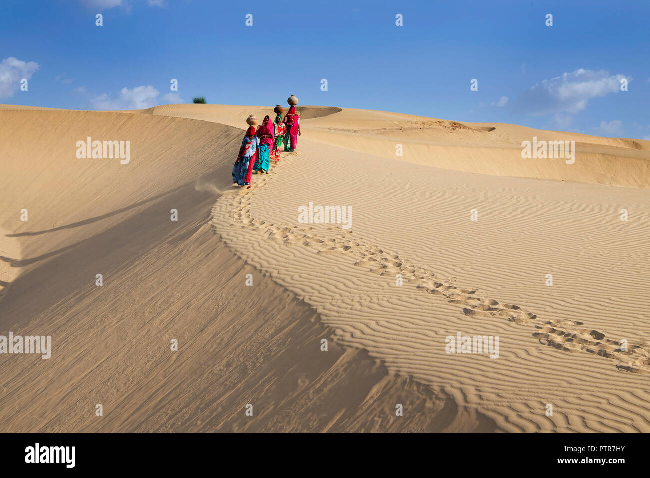 Das Bild der Rajasthani traditionelle Damen mit Töpfe in den Sanddünen von Jaisalmer, Rajasthan, Indien Stockfoto