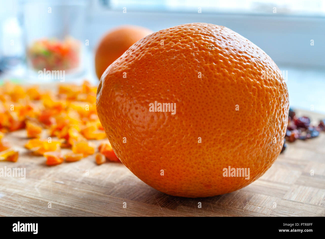 Orangen, gehackte getrocknete Aprikosen und Pflaumen auf einer hölzernen Schneidebrett. Gesunde Ernährung Food Ingredients. Stockfoto