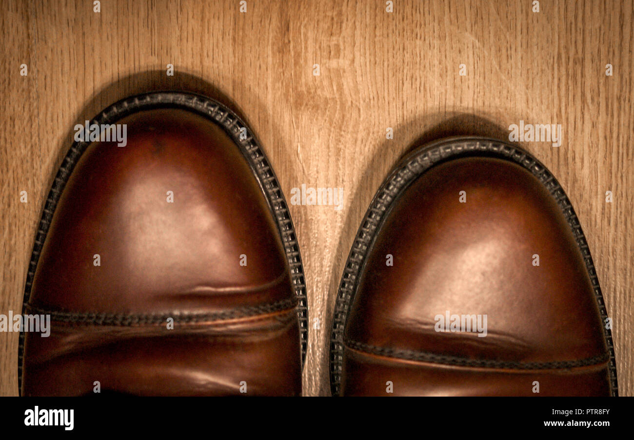 Die Zehen von verschlissenen Braun Leder Herren Schnürer auf Holzboden Hintergrund. Ansicht von oben. Stockfoto