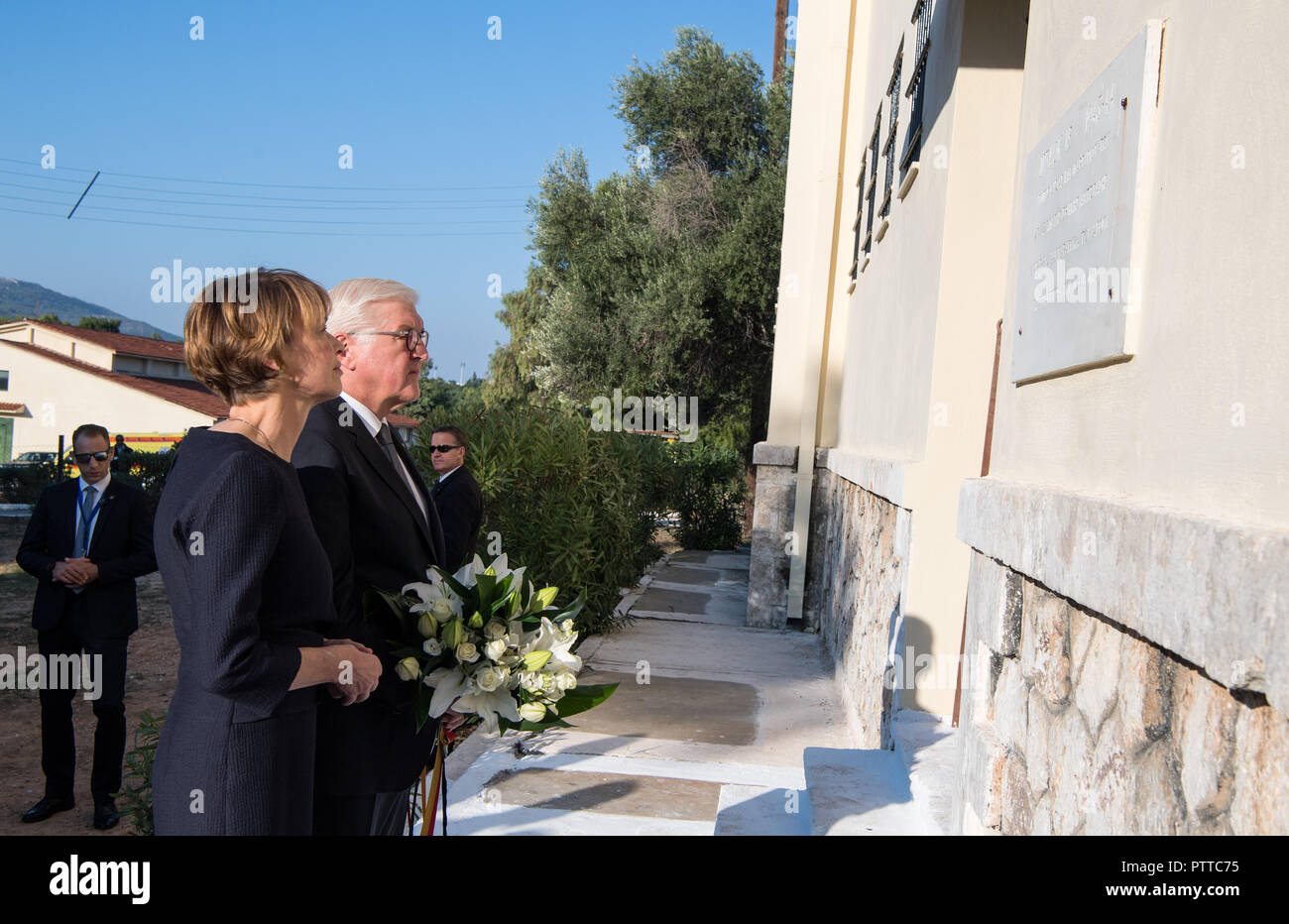 Athen, Griechenland. 11 Okt, 2018. Bundespräsident Dr. Frank-Walter Steinmeier und seine Frau Elke Büdenbender legen ein Blumenarrangement vor einer Gedenktafel bei einem Besuch im ehemaligen KZ Chaidari westlich von Athen. Präsident Steinmeier und seine Frau sind auf einer dreitägigen Staatsbesuch in Griechenland. Quelle: Bernd von Jutrczenka/dpa/Alamy leben Nachrichten Stockfoto