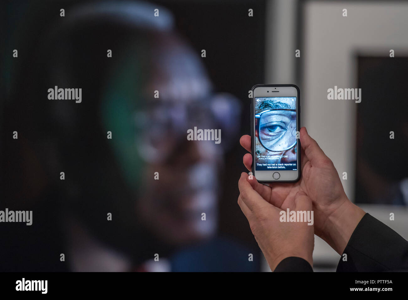 London, Großbritannien. 10. Oktober, 2018. Mithilfe des App, in der Sie sehen können, die Personen Interview an Ihrem Portrait hingewiesen - Schwarz ist das neue Schwarz: Porträts von Simon Friedrich in der National Portrait Gallery, London, größte Akquisition der Galerie Porträts von afro-karibischen (auf Anzeige bis 27. Januar 2019). Credit: Guy Bell/Alamy leben Nachrichten Stockfoto