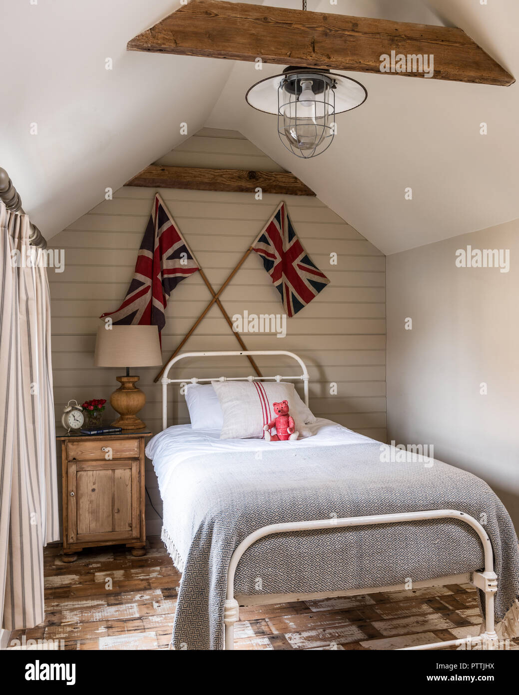 Einzelbett mit Union Jacks und aufgearbeitete Holzdielen Stockfoto