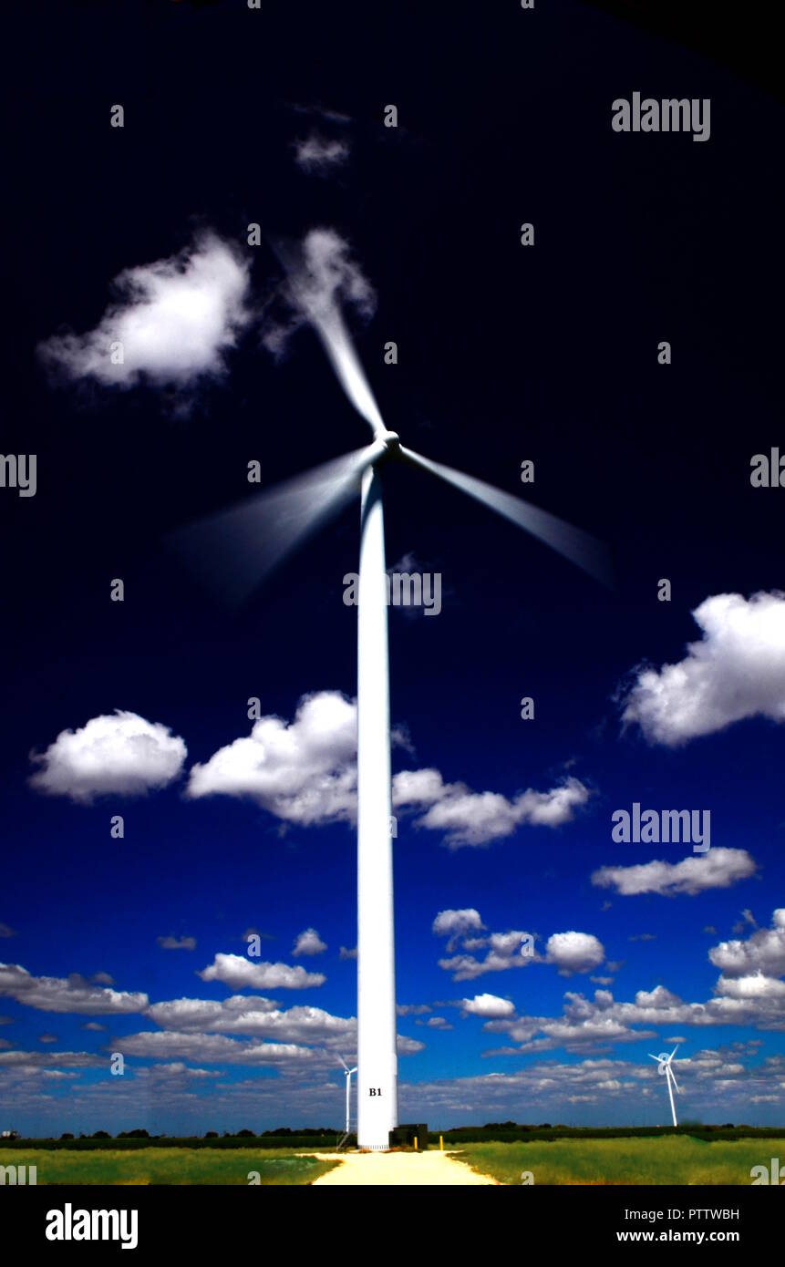 Die Bewegung der Propeller einer Windkraftanlage spinnen gegen einen dunklen blauen Himmel Stockfoto