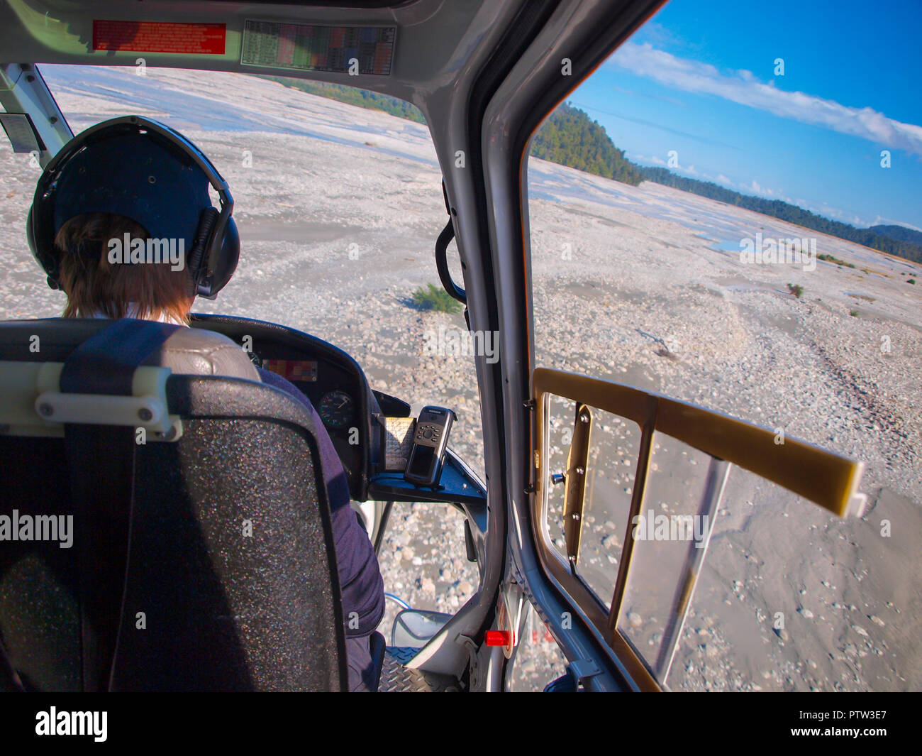 Helikopterflug über eine schroffe Wildnis breiten Flussbett Landschaft in Neuseeland, vom Cockpit aus gesehen Stockfoto