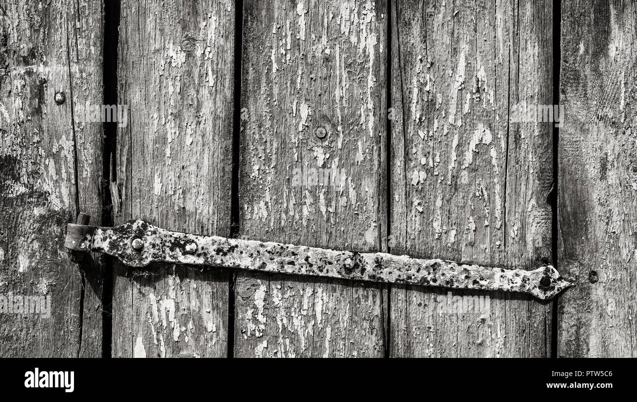 Alten rustikalen Wicket in Schwarz und Weiß. Gestreifte Holz- Textur. Künstlerische close-up vintage Holz Tür und rostiges Metall Scharnier. Zusammenfassung Hintergrund. Stockfoto