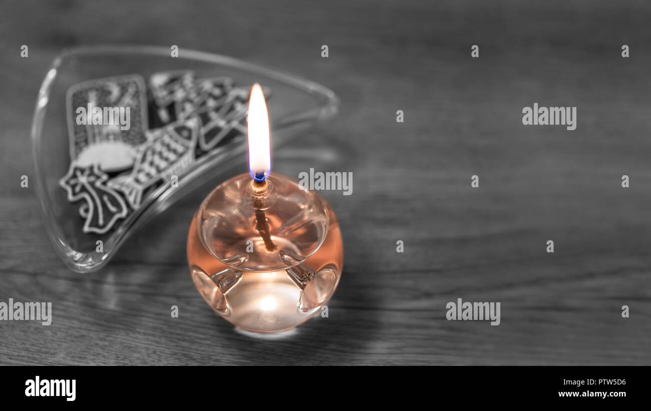 Schönes Glas Lampe mit Aromaöl. Reich verzierte Weihnachten Lebkuchen. Orange brennende Kerze. Schwarz-weiß verschwommen Holz Hintergrund, Schüssel mit Süßigkeiten. Stockfoto