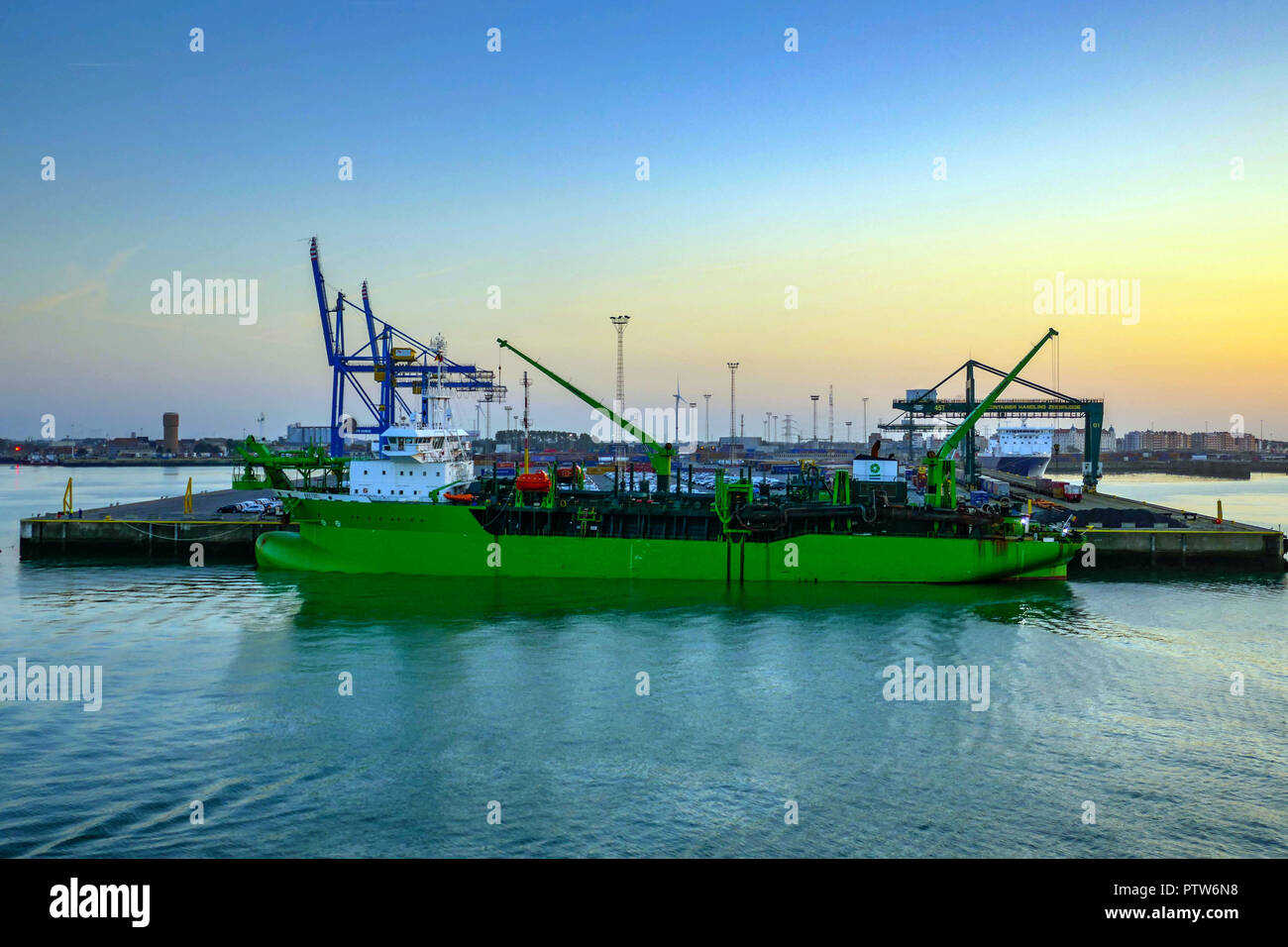 Krane und Boot, Breydel, Schwimmbagger, im Hafen, Hafen, von der Fähre bei Sonnenuntergang gesehen, Zeebrugge Hafen, Belgien, Stockfoto