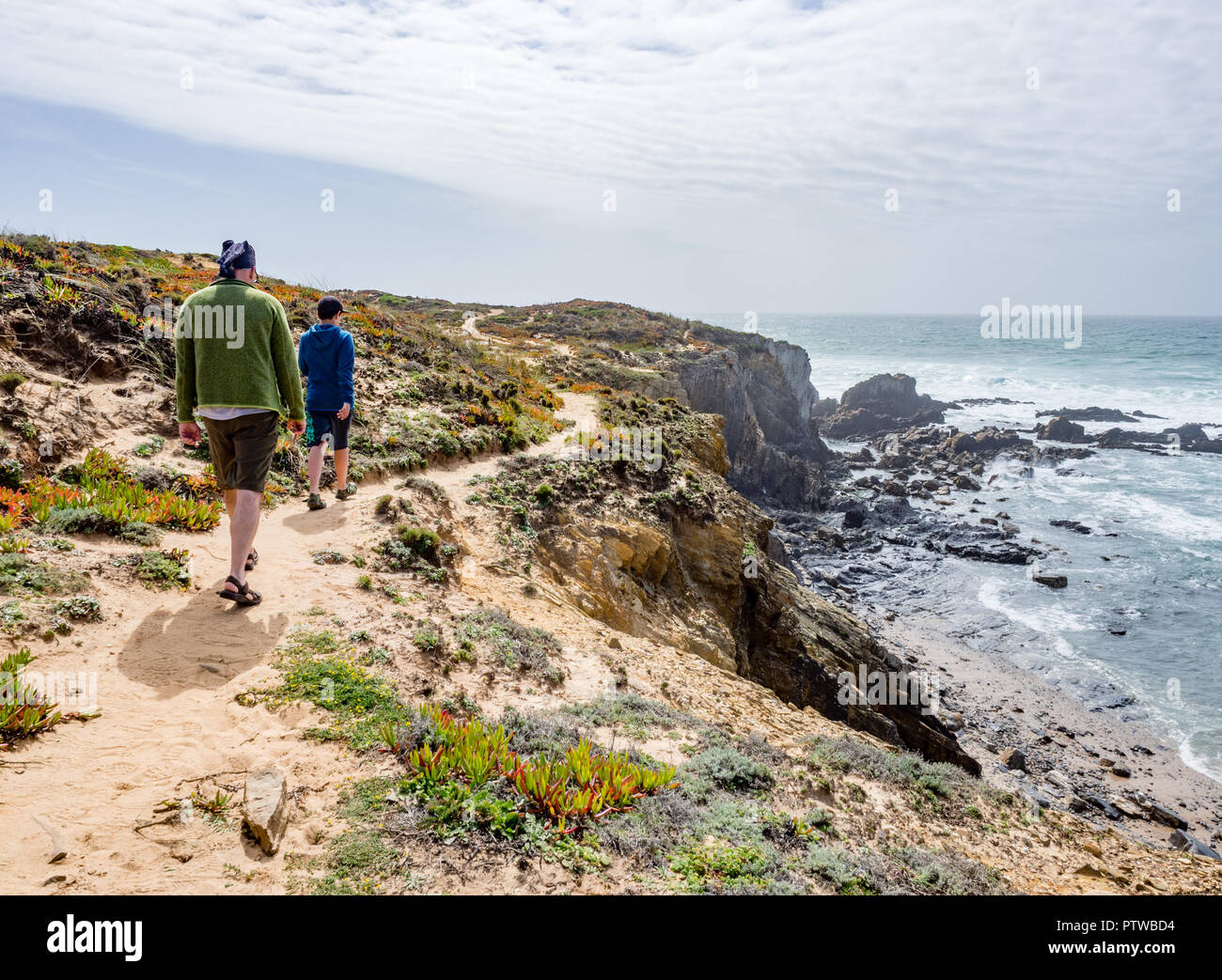 Vater und 10-jährigen Sohn Wandern am Praia de Almograve, Alentejo, Costa Vicentina Küste von Portugal Stockfoto