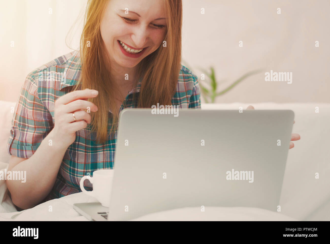Mädchen lacht Arbeiten für den Laptop. Stockfoto