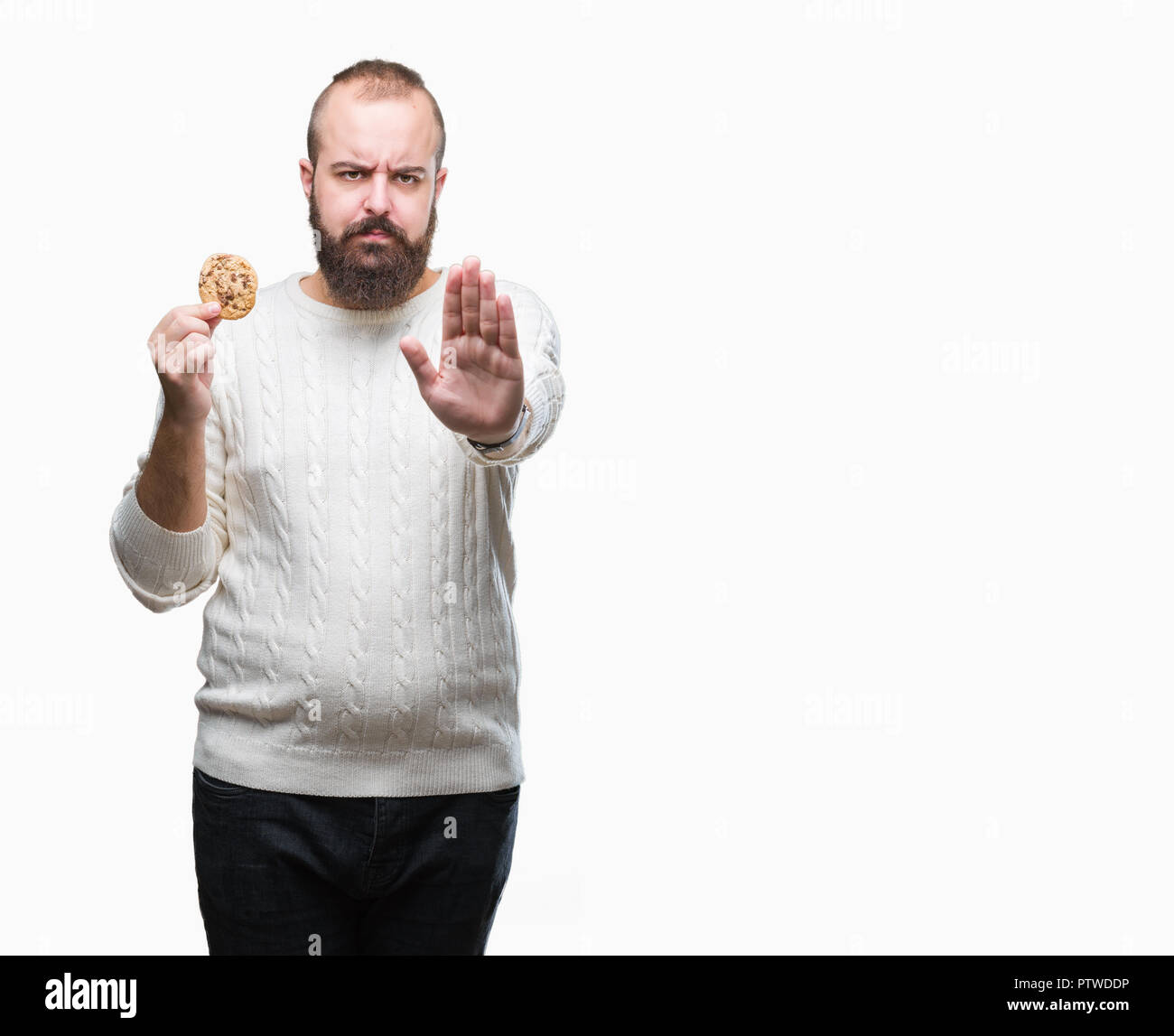 Junge hipster Mann essen Chocolate Chips Cookies über isolierte Hintergrund mit der offenen Hand tun, STOP-Schild mit ernsten und selbstbewussten Ausdruck, Verteidigung Stockfoto