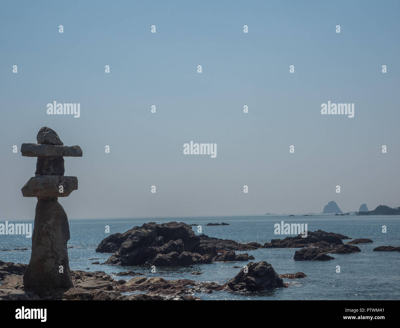 Stein Laterne ishidoro, auf felsigen Ufer, sonnigen Tag, blaues Meer und ferne Inseln, Pazifik, Minami, Tokushima, Japan Stockfoto