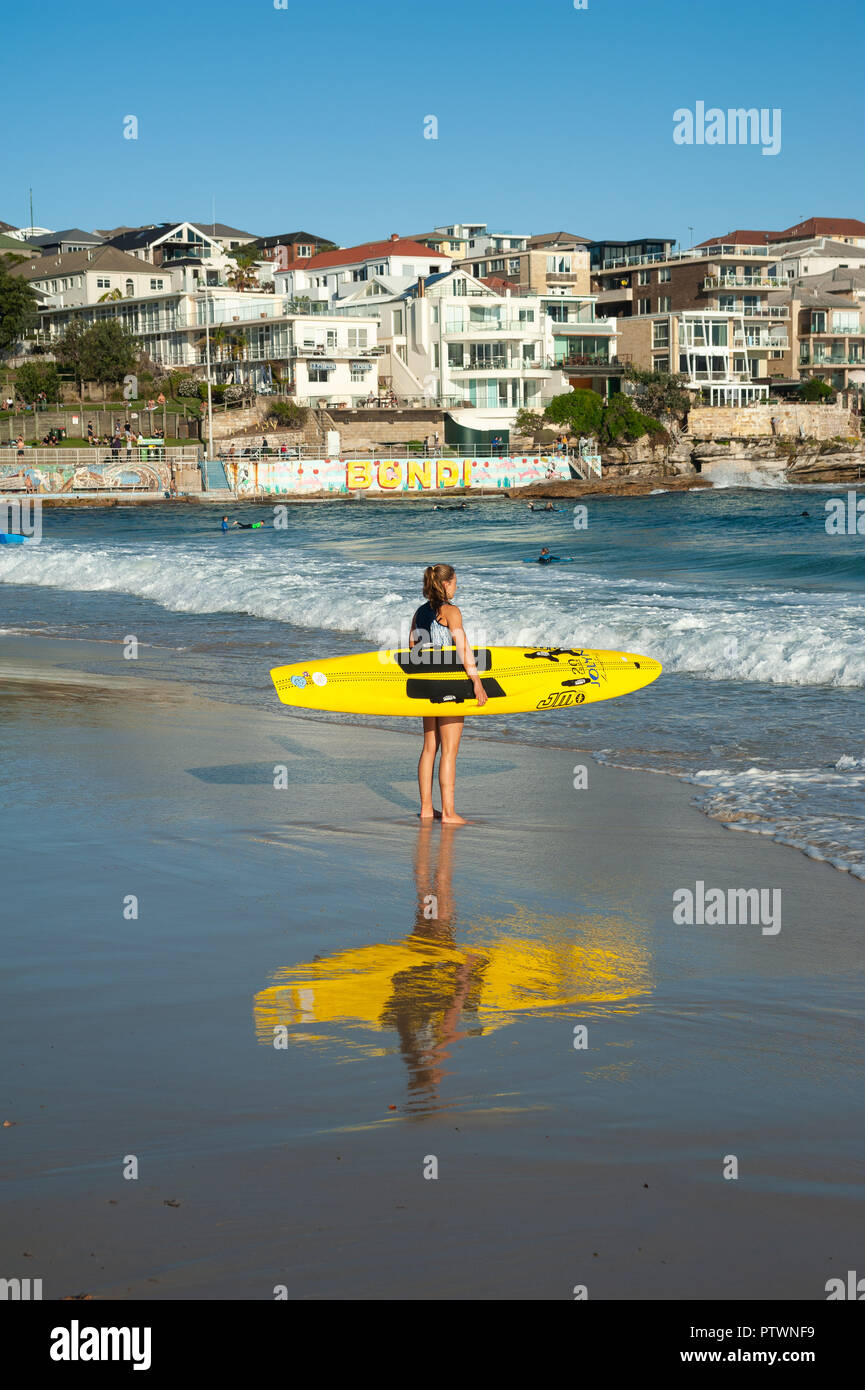 21.09.2018, Sydney, New South Wales, Australien - eine junge weibliche Surfer gesehen wird Ihr Surfboard Holding, als sie auf dem offenen Meer am Bondi Beach blickt. Stockfoto