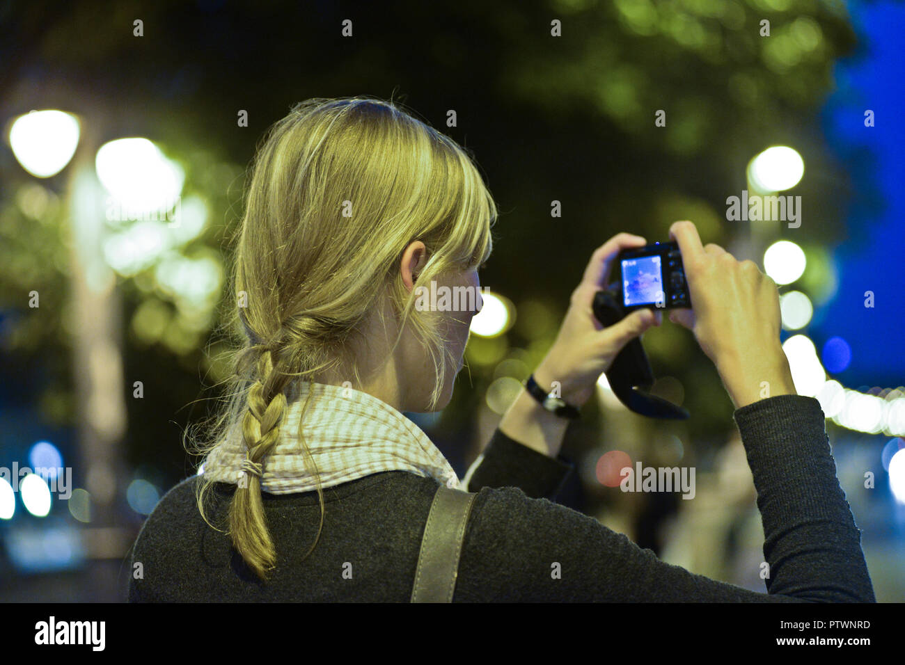 Ein blondes Mädchen, das nachts in Budapest fotografiert Stockfoto