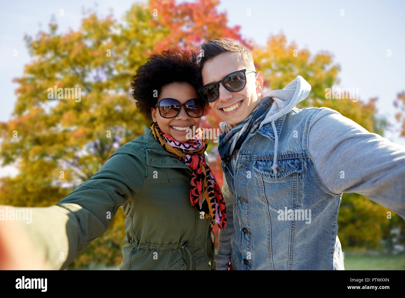 Happy Mixed Race Paar unter selfie im Herbst Stockfoto