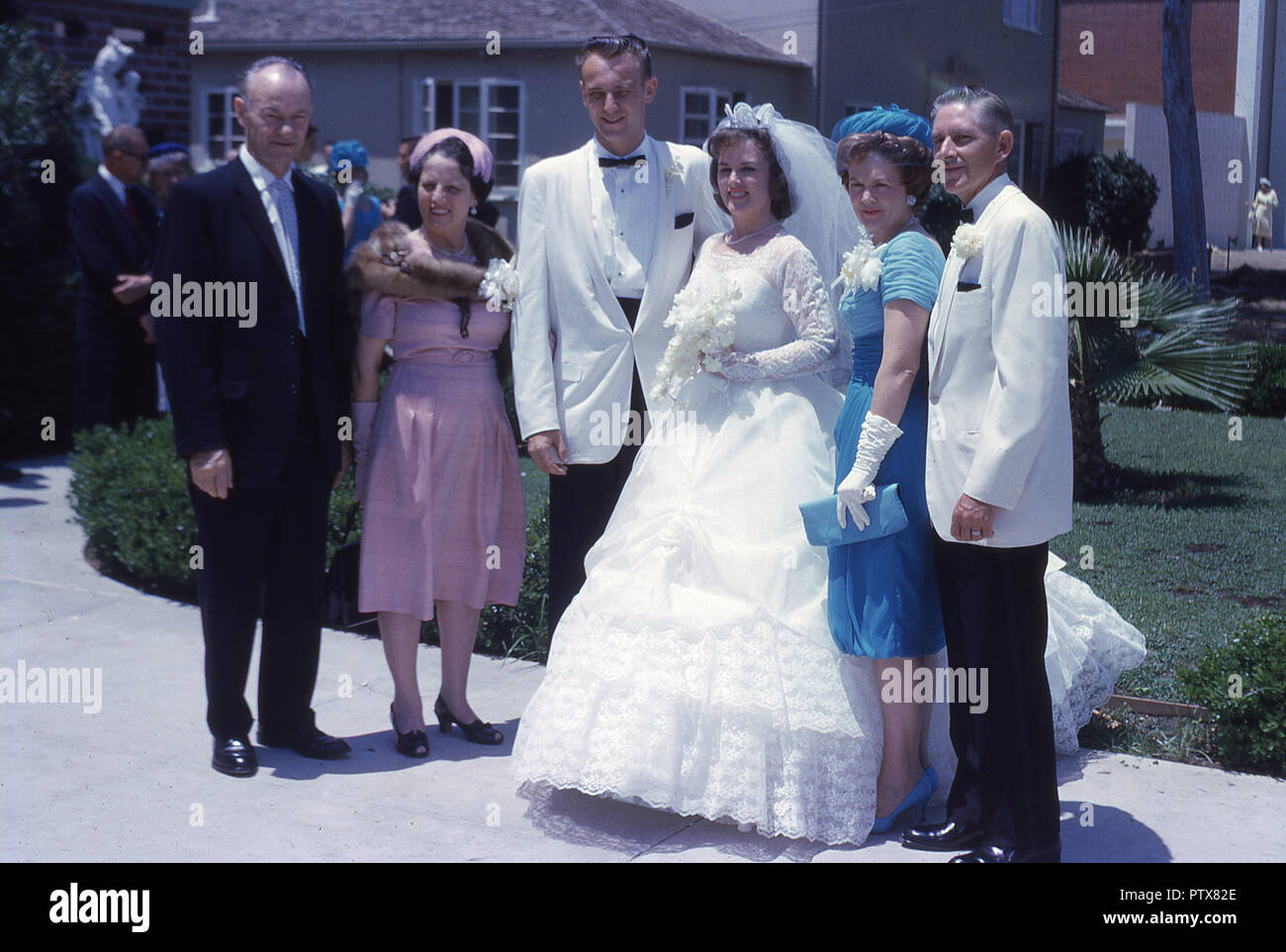 1962, historische, Hochzeit, Braut und Bräutigam Line up im Freien unter der Sonne mit ihren jeweiligen Verwandten für ein Foto, Kalifornien, USA. Stockfoto