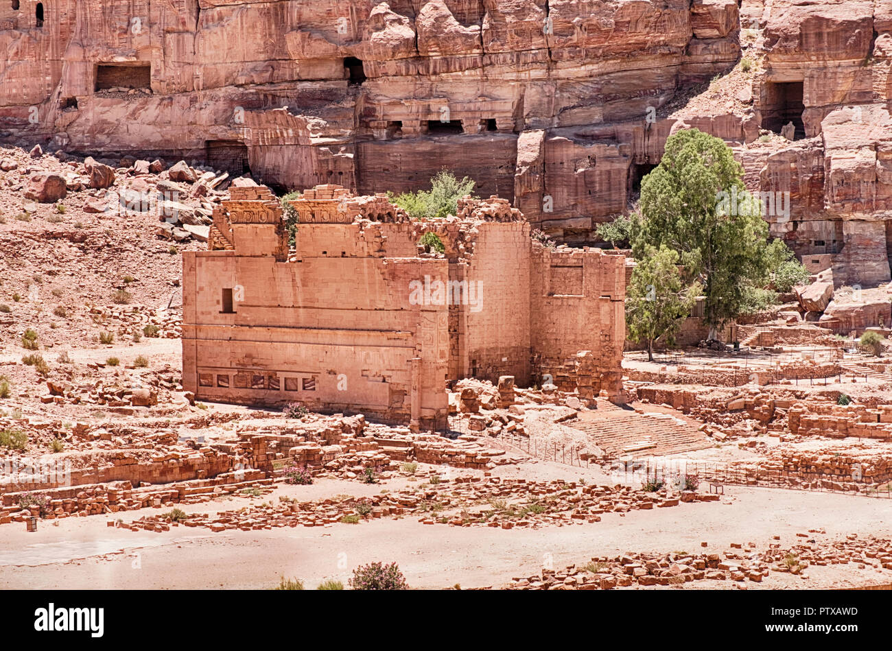 Die Ruinen des Tempels von Dushares am Ende der Römischen Kolonnaden stehen unter einigen der Gräber in die Felswände von Petra in Jordanien. Stockfoto