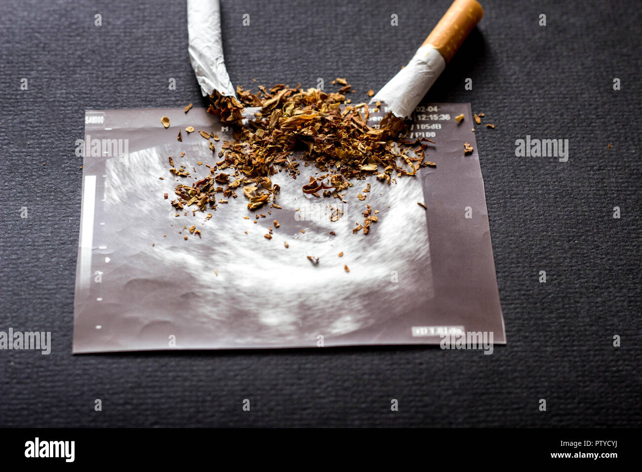 Zerbrochene Zigarette auf ein Bild von der Schwangerschaft Uzi, Rauchen und Schwangerschaft, Schwangerschaft und Zigarette Stockfoto