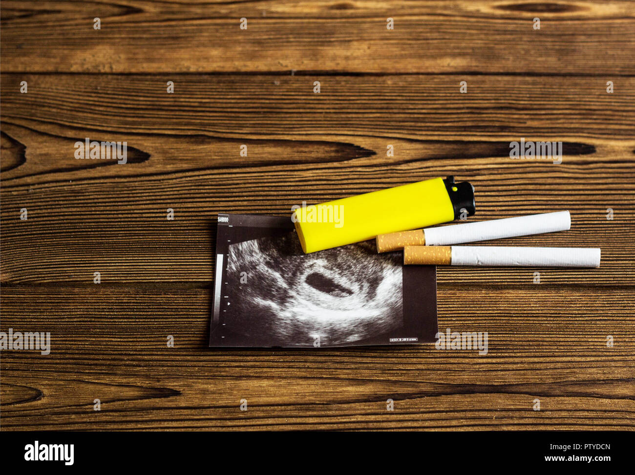 Zigarette und Feuerzeug liegen auf dem Bild von uzi Schwangerschaft, Rauchen und Schwangerschaft, Schwangerschaft, Holz- Hintergrund Stockfoto