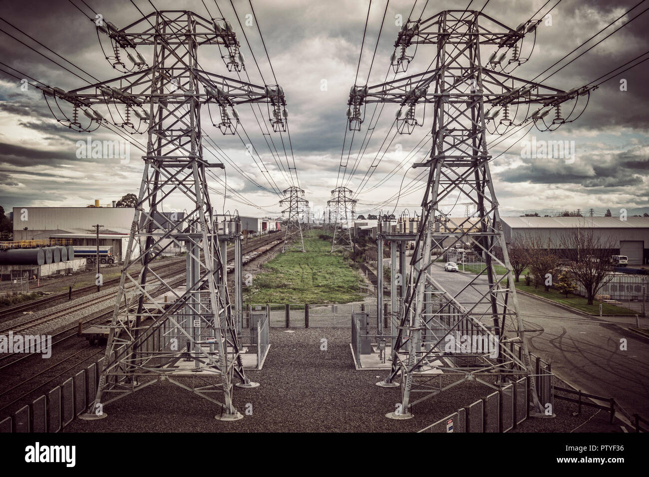 High-voltage power distribution Linien und Eisenbahn unter dramatischen Himmel; Instagram type Filter. Stockfoto