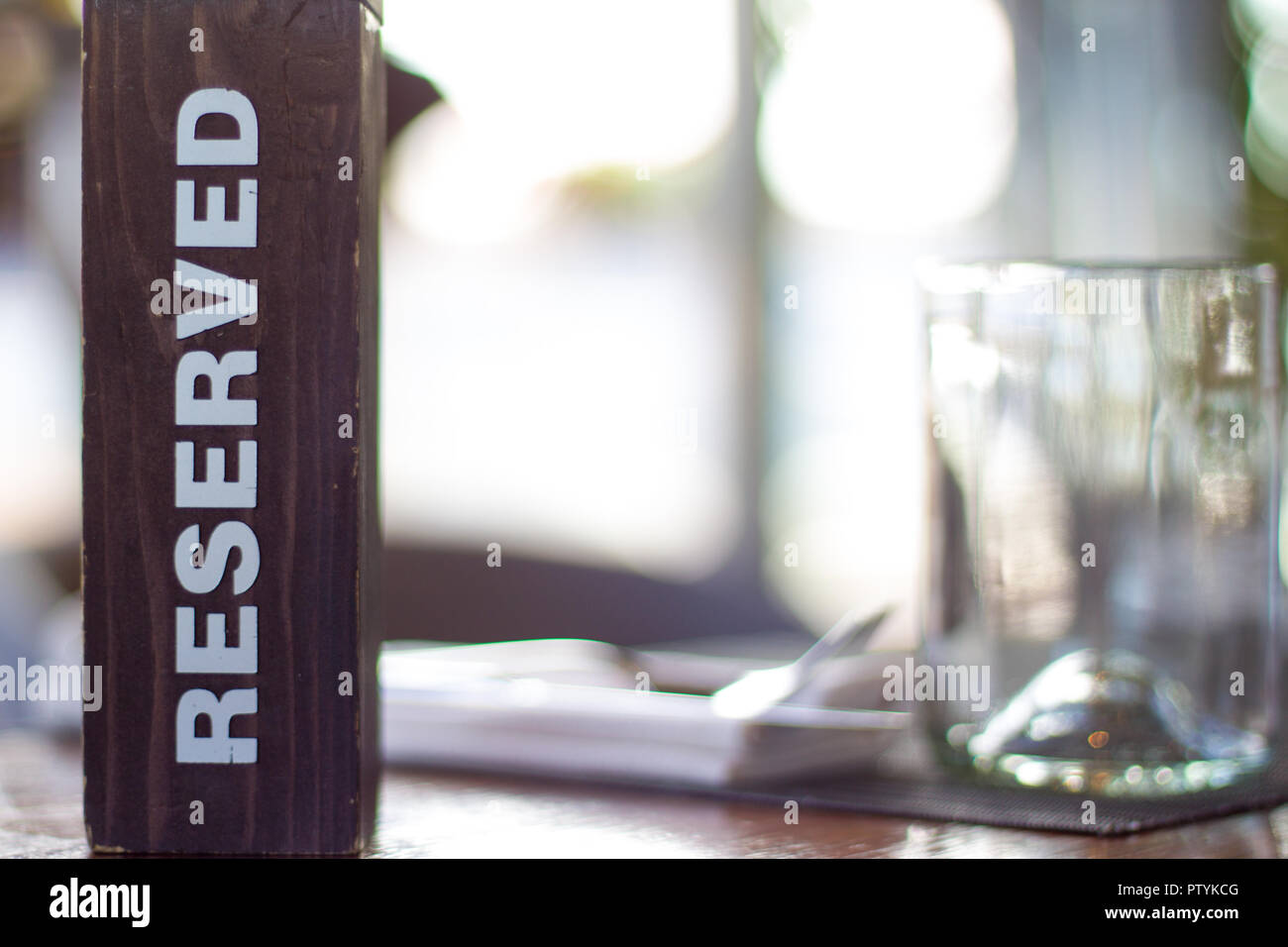 Holz- Karte Platte auf dem Tisch mit verschwommenen Hintergrund reserviert. Reservierung Sitz im Restaurant. - Freizeit, Menschen- und Servicekonzept. Stockfoto