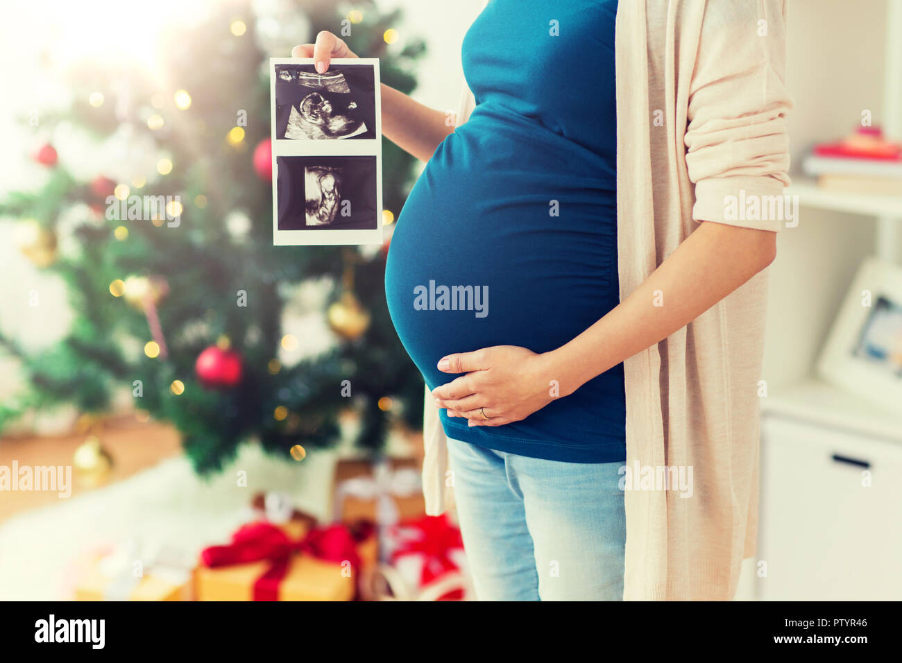 Schwangere Frau mit Ultraschall Bilder zu Weihnachten Stockfoto