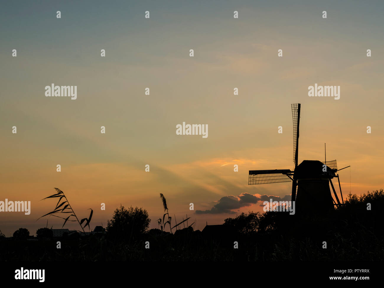 Silhouette einer holländischen Windmühle bei Kinderdijk, Rotterdam, bei Sonnenuntergang Stockfoto