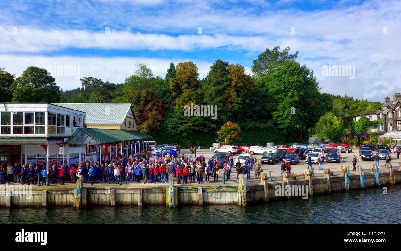 Passagiere in der Warteschlange für Windermere See Kreuzfahrten Boot zu Bowness on Windermere am Kai an der Lakeside, Lake District, Cumbria, England, Großbritannien Stockfoto